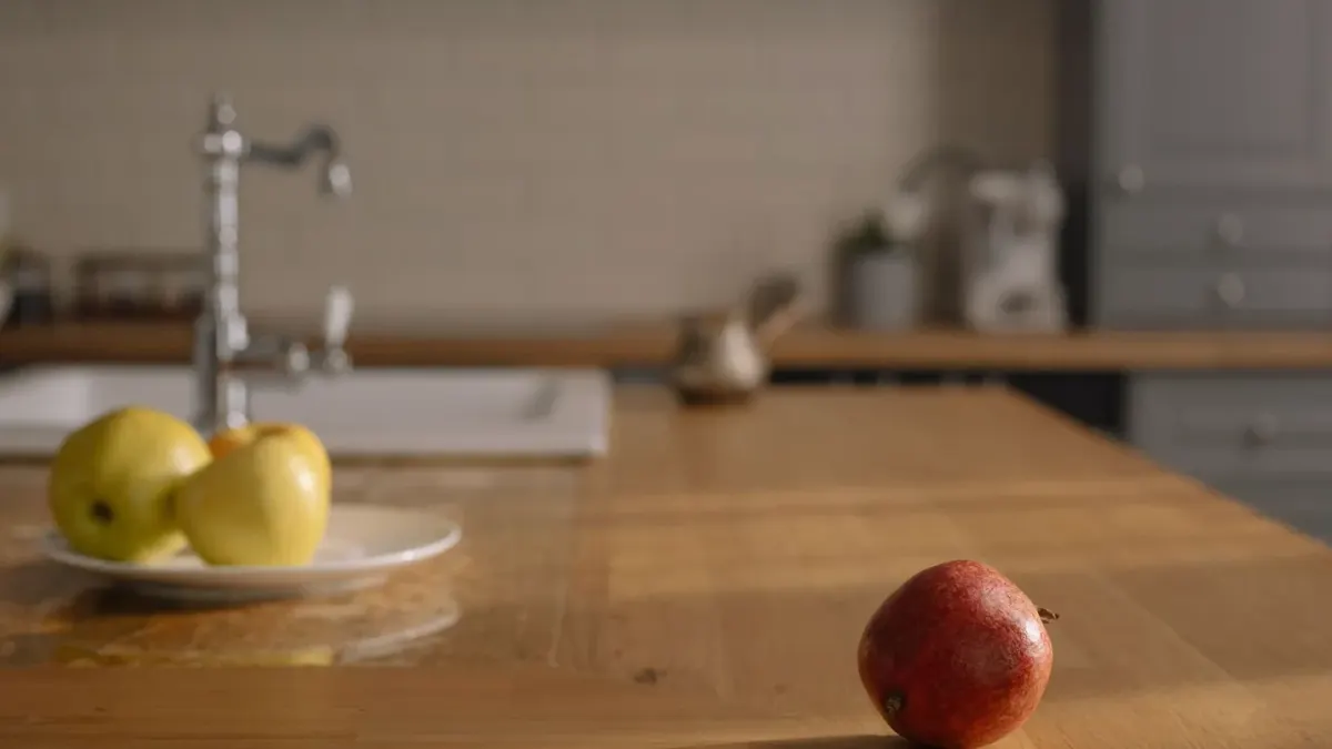 A dog sniffing a plate of sliced apple on a kitchen counter