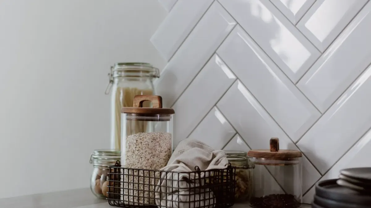 A measuring scoop of supplement powder resting beside a jar on a kitchen counter