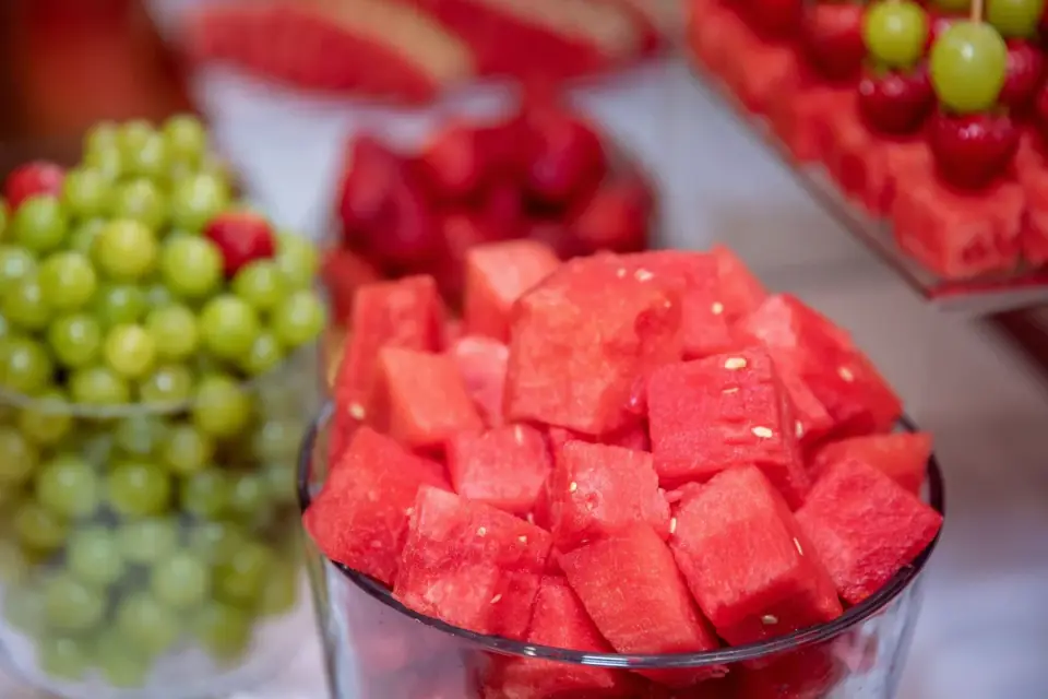 Cubed watermelon flesh on a cutting board with the rind trimmed away
