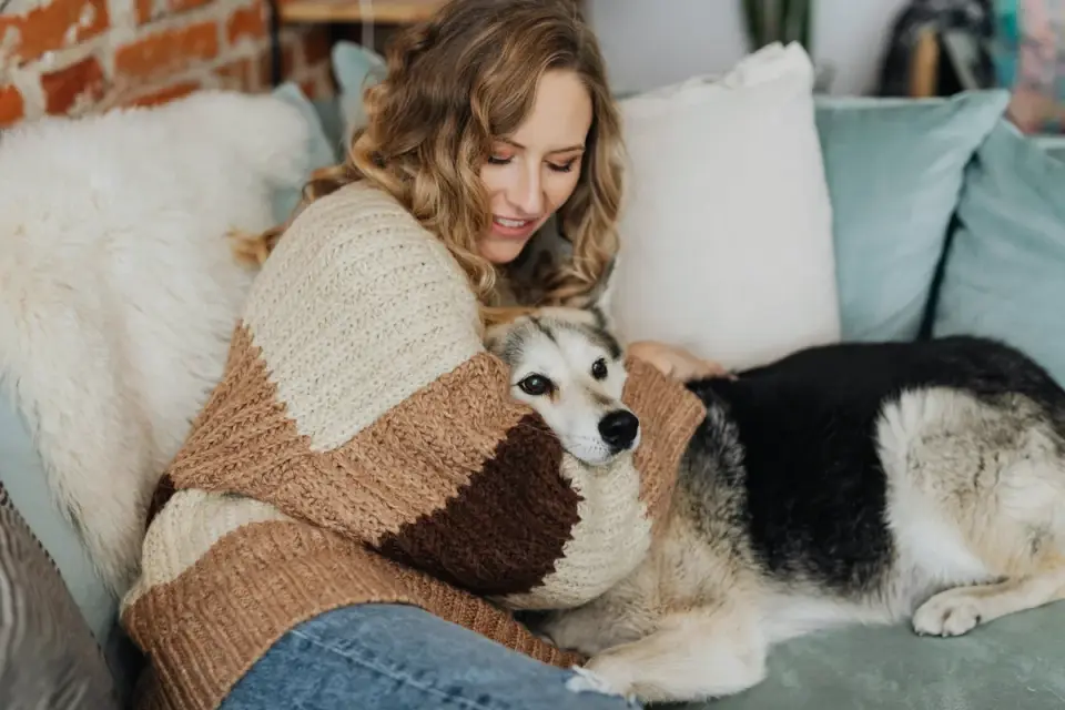 Dog owner comforting dog home