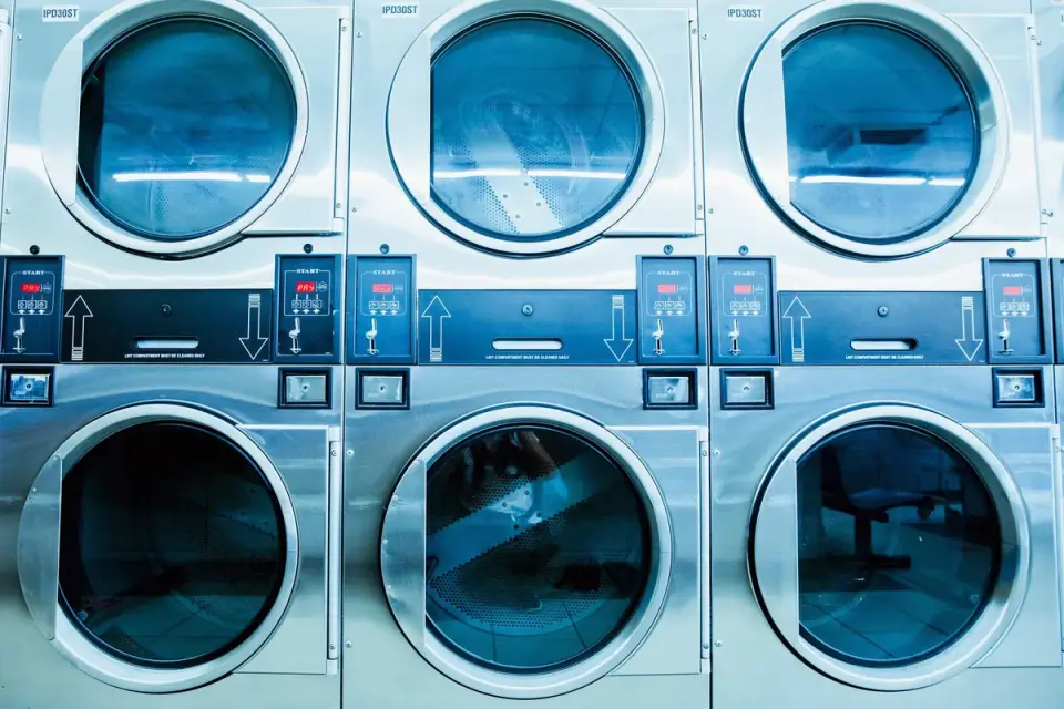 Plush dog toys placed inside a mesh laundry bag before a washing machine cycle